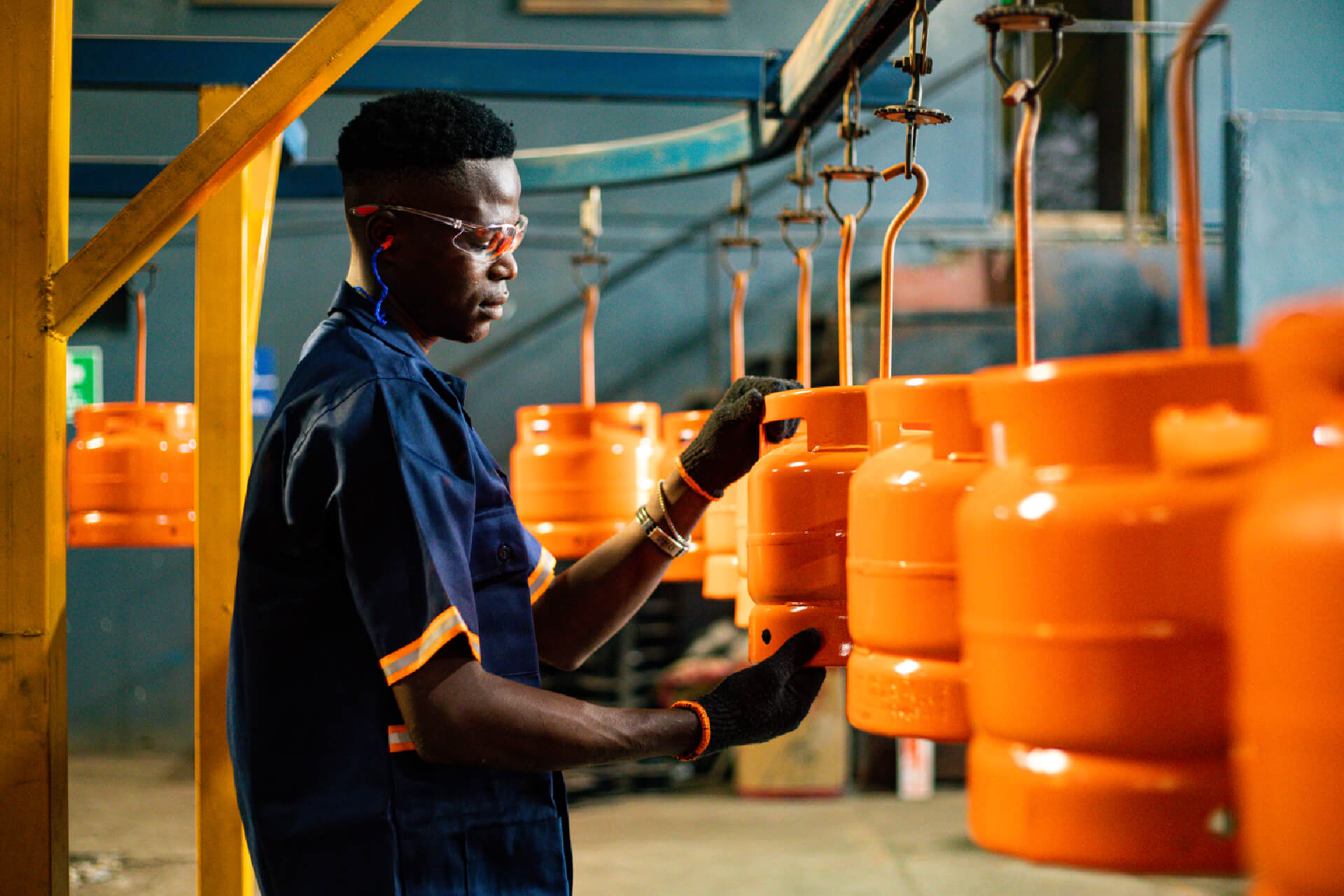 A Zen Limited's worker carefully inspecting a gas cylinder to ensure quality and safety.