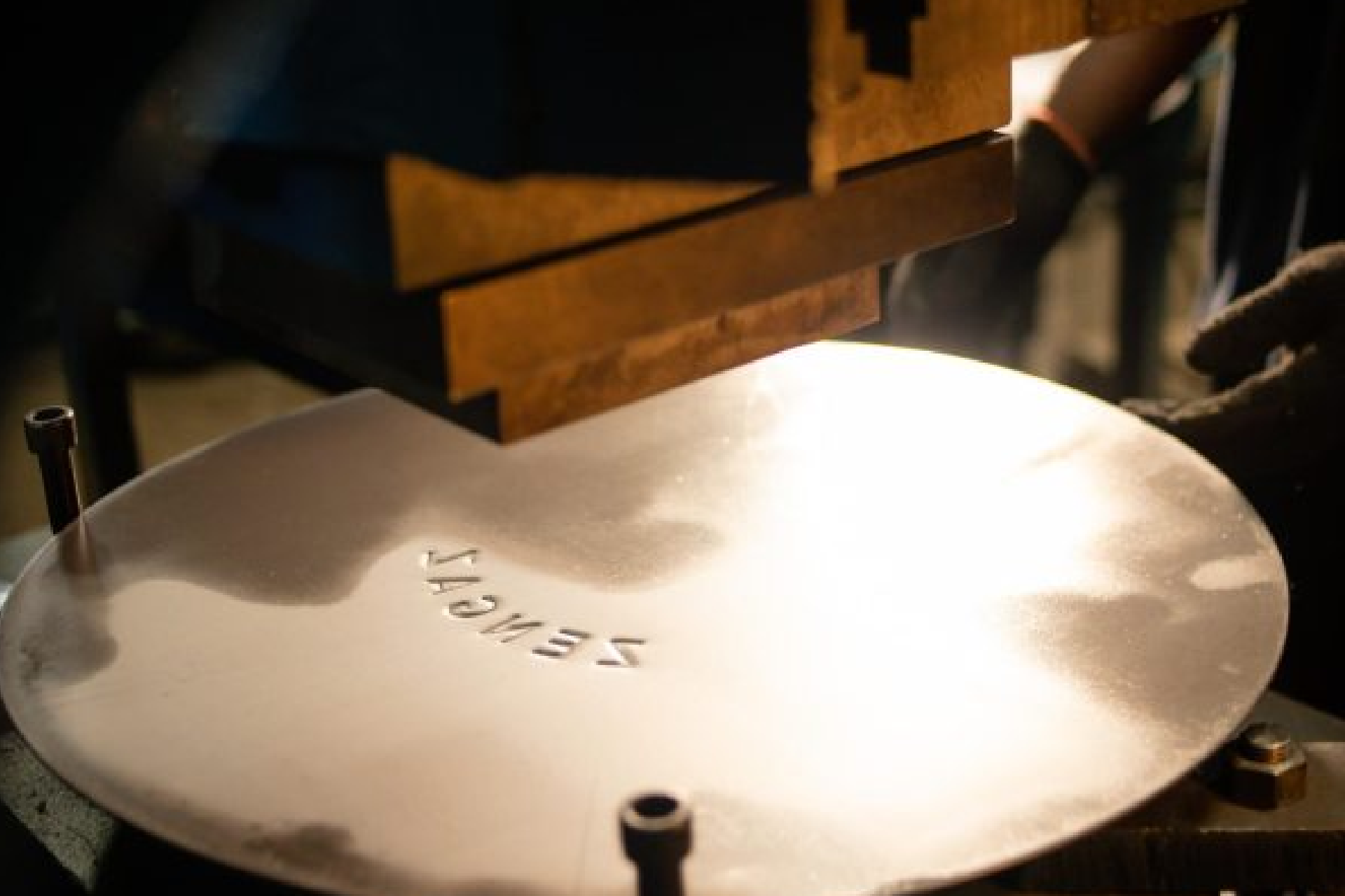 A metal disc being branded in a factory. Highlighting the manufacturing process of products at Zen Limited.